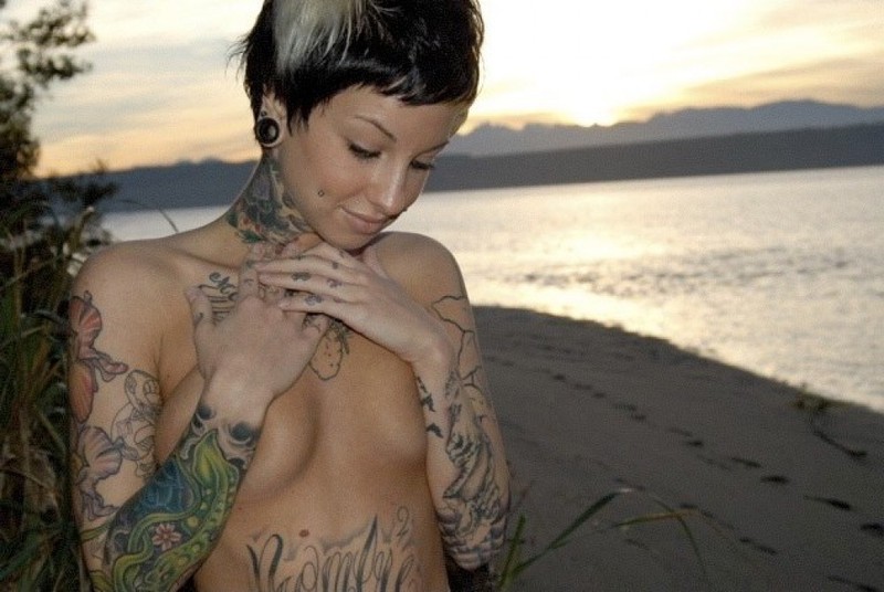 Татуированная неформалка позирует на берегу водоема 1 фотография