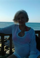 Блондинистая мамка позирует на фоне розовой стены без лифа 8 фотография